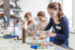 Junge Maedchen bedienen Laborgeraete